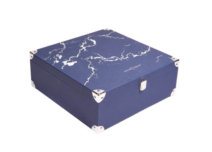 An ornate tea treasure chest filled with loose leaf tea caddy, glass teacups, glass teapot and tea timer accessories